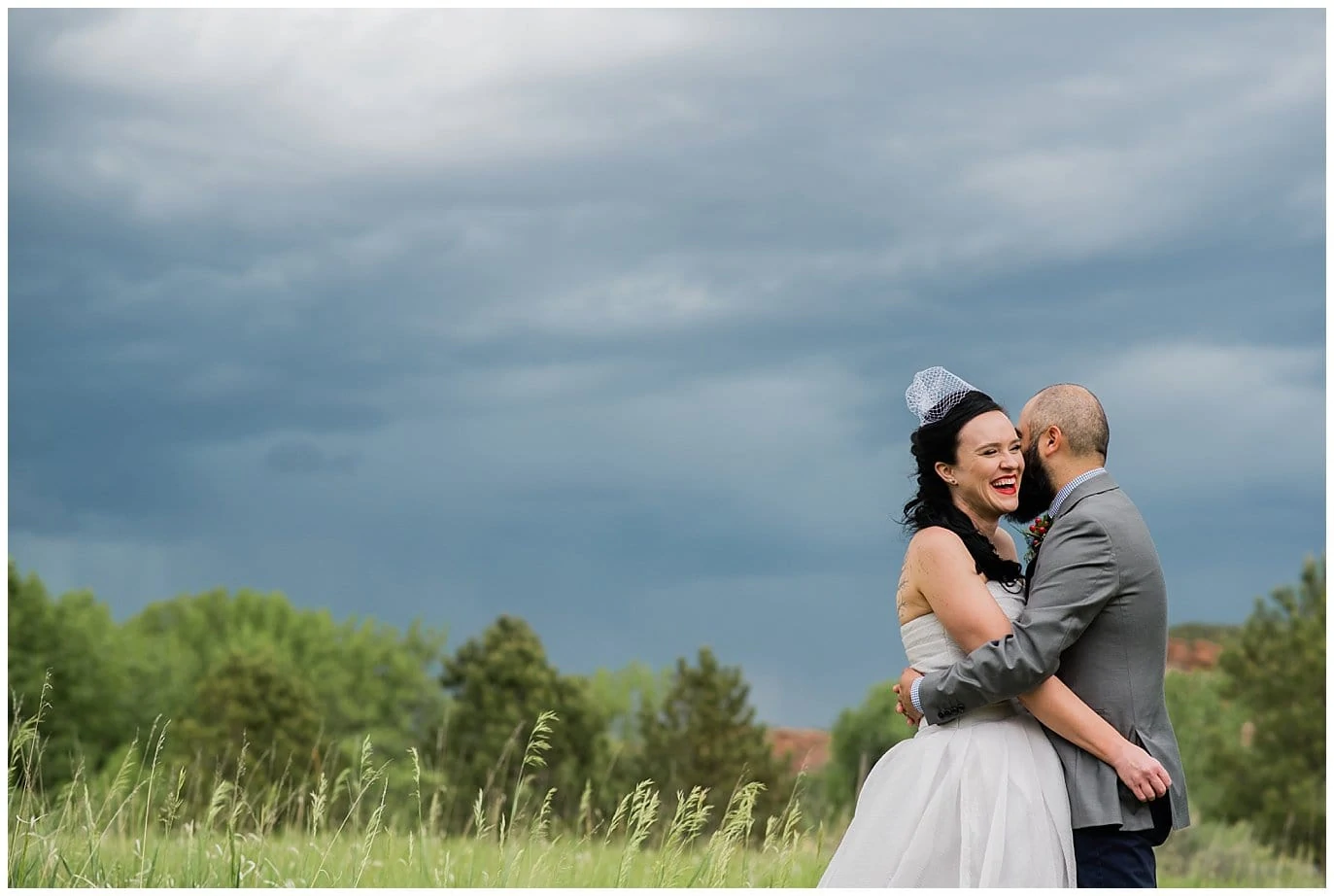 bride and groom cuddle under stormy skies fort collins wedding photo