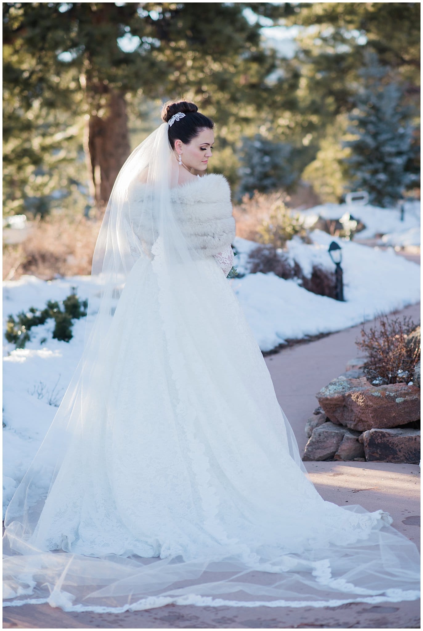 Bride in long sleeved lace dress with fur and veil photo
