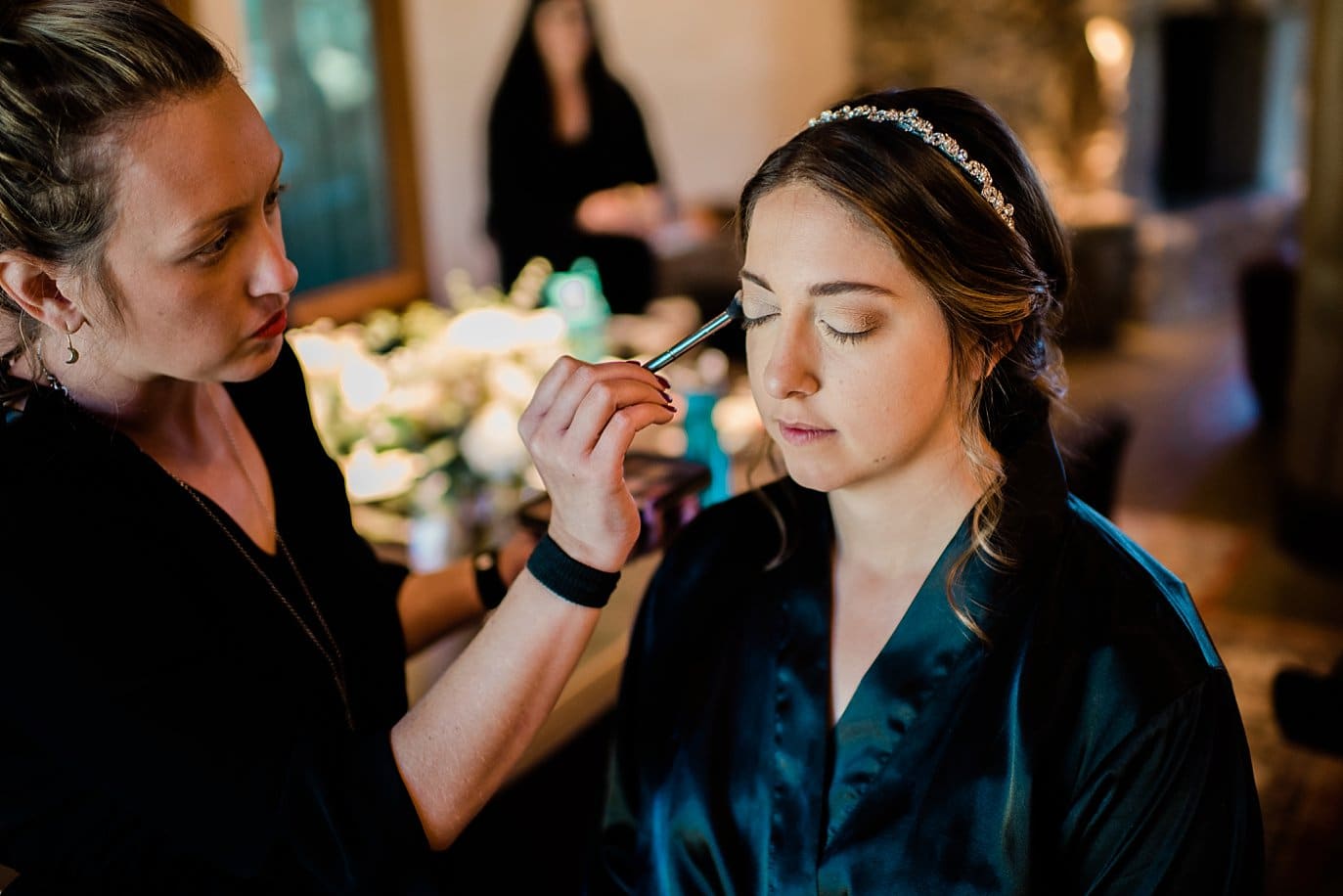 bride getting eye makeup done at VRBO by Tabernash Wedding Photographer Jennie Crate