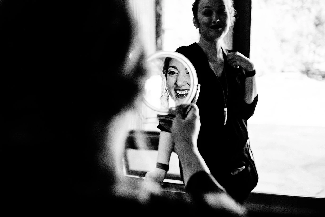 bride checks out wedding makeup in mirror at VRBO house by Winter Park Wedding Photographer Jennie Crate