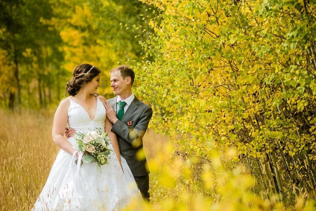 Bride and groom in yellow aspens in fall at B Lazy 2 Ranch wedding by Fraser wedding photographer Jennie Crate