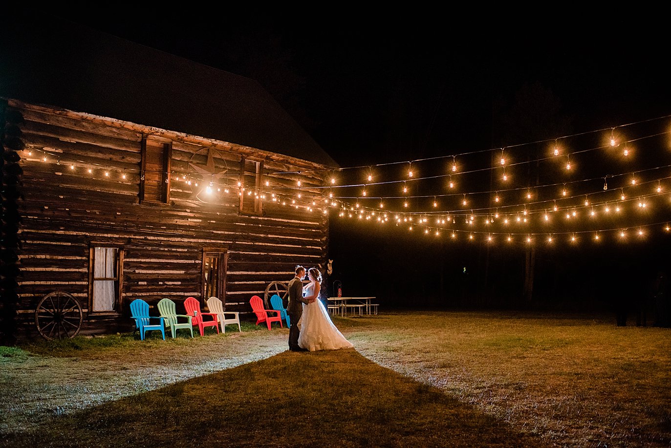 bride and groom night portrait under barn market lights at B Lazy 2 Ranch by Winter Park wedding photographer Jennie Crate