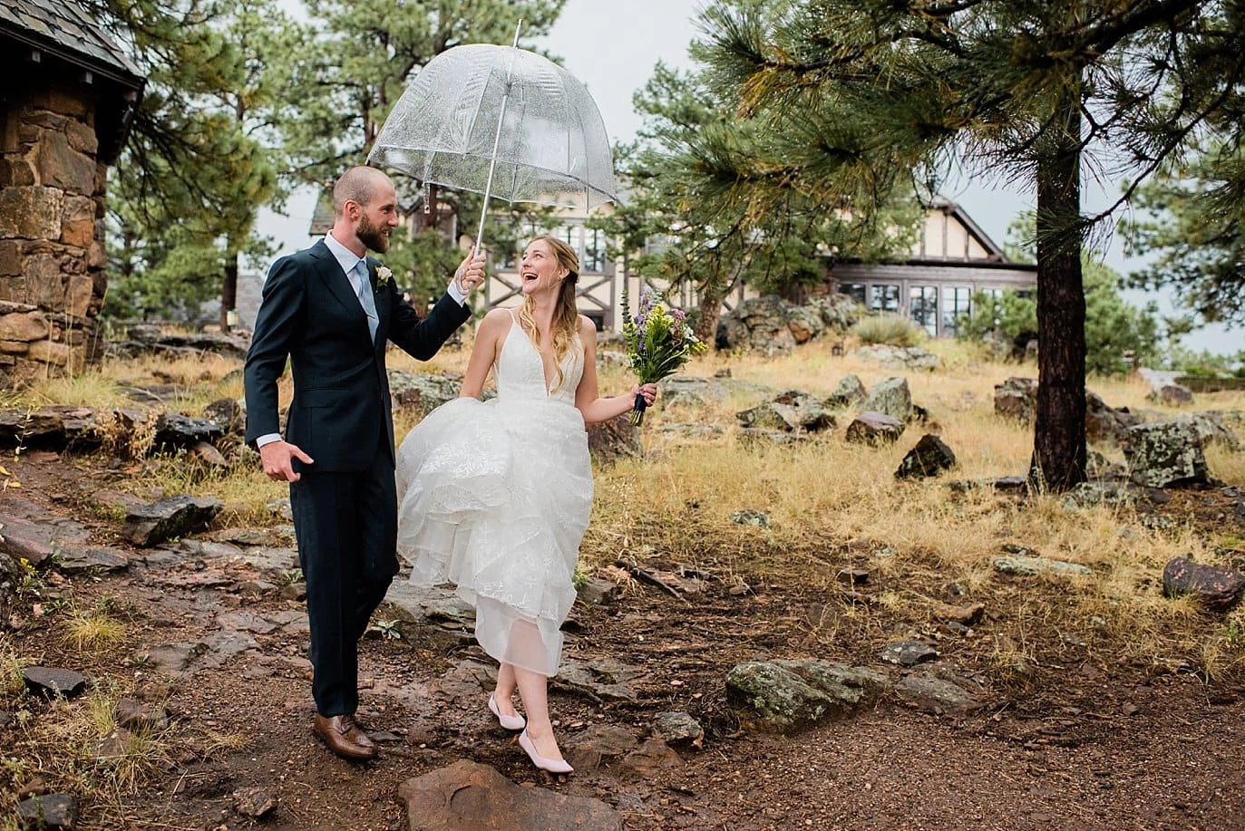 bride and groom with umbrella at rainy Boettcher Mansion wedding by Denver Wedding Photographer Jennie Crate, Photographer