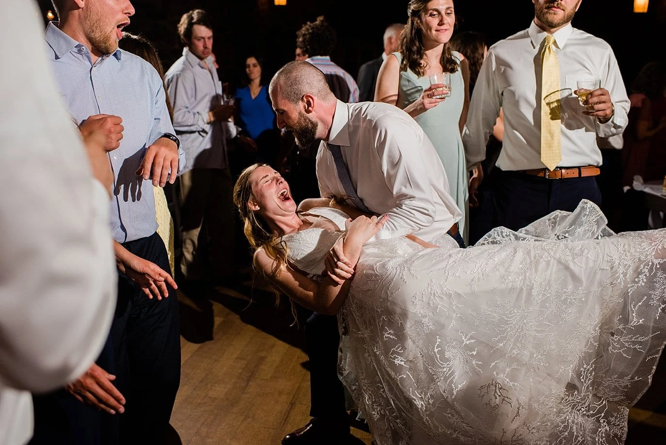 groom dips bride on dance floor at fall colorado wedding