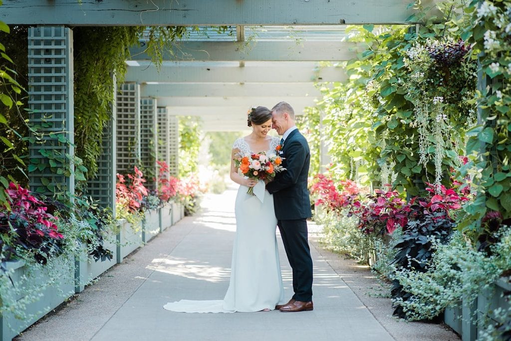 bride and groom under arbor at Denver Botanic Gardens wedding by Denver Wedding Photographer Jennie Crate Photographer