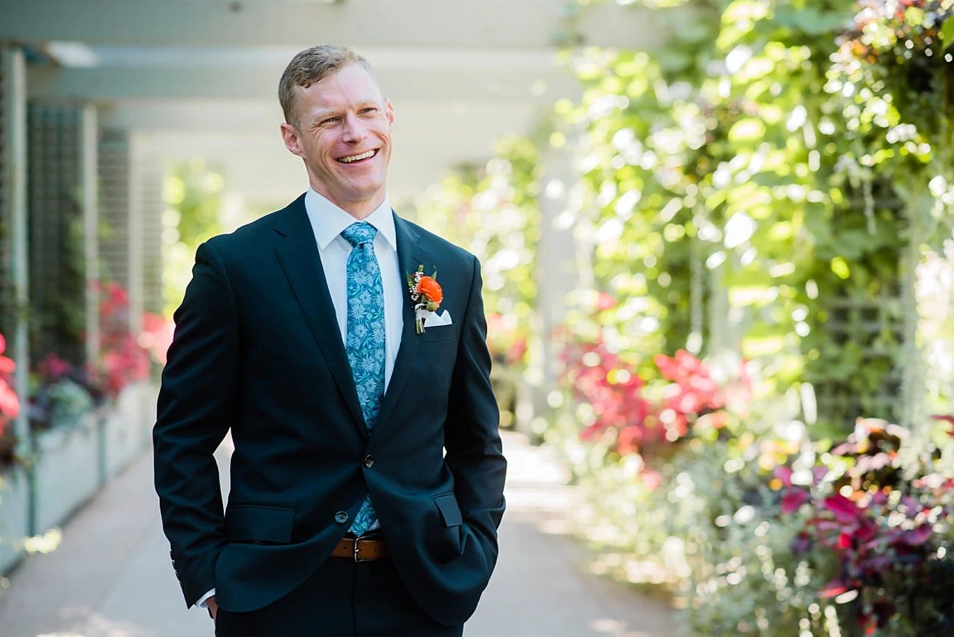 groom portrait in navy suit with orange flower at Denver Botanic Gardens Wedding by Denver Wedding Photographer Jennie Crate