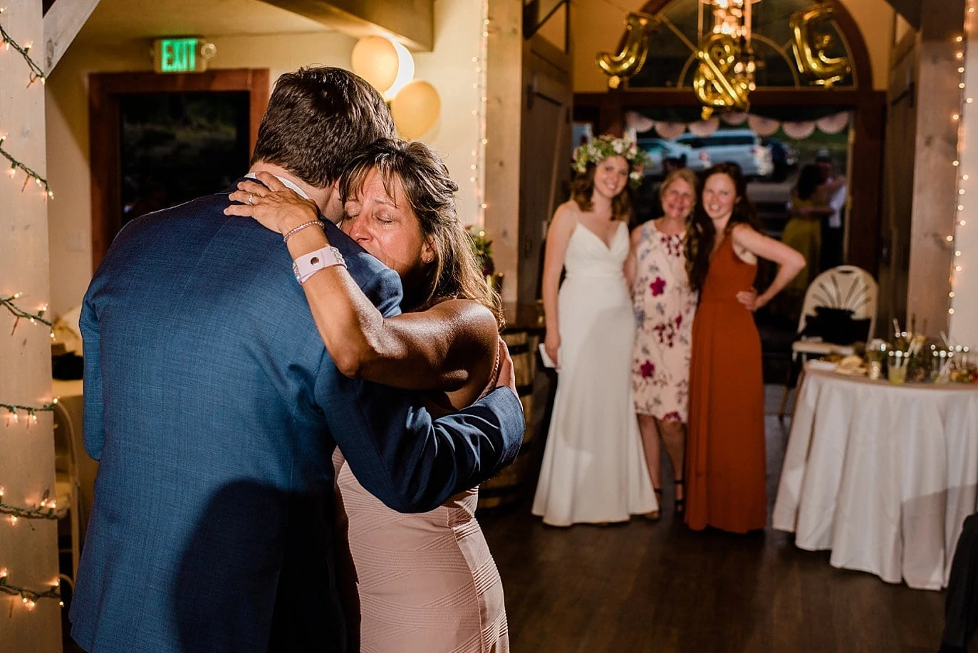 mother and son dance with bride looking on photo