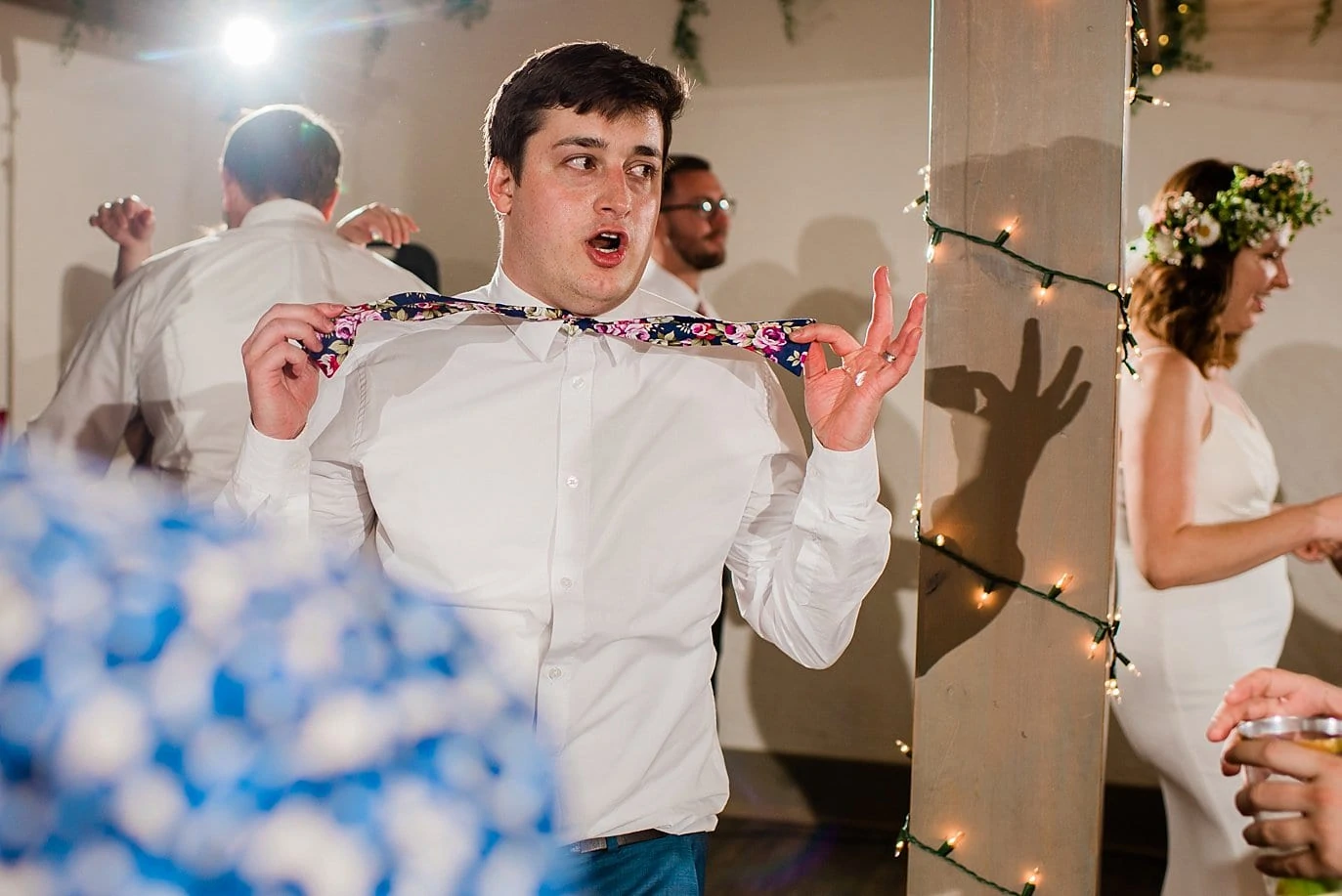 groom dancing with bow tie at wedding reception photo
