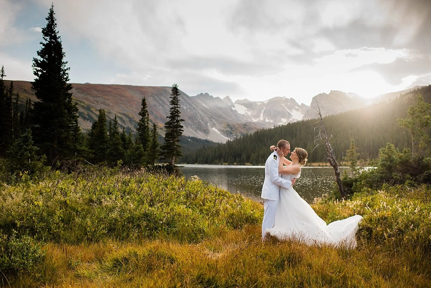 bride and groom in field by Long Lake after Colorado elopement
