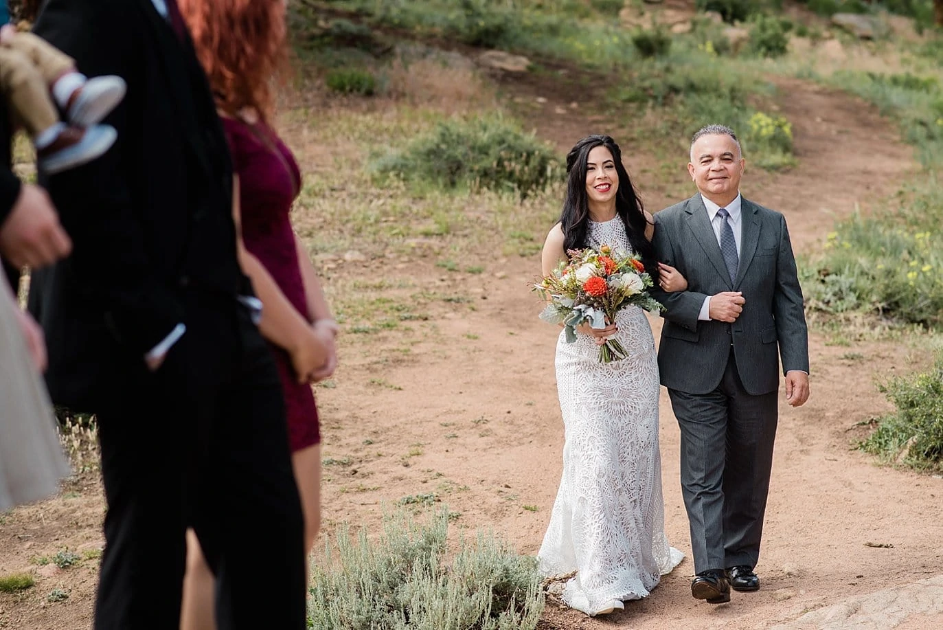Bride walking down aisle as guests sing at Rocky Mountain National Park Wedding by RMNP Wedding Photographer Jennie Crate