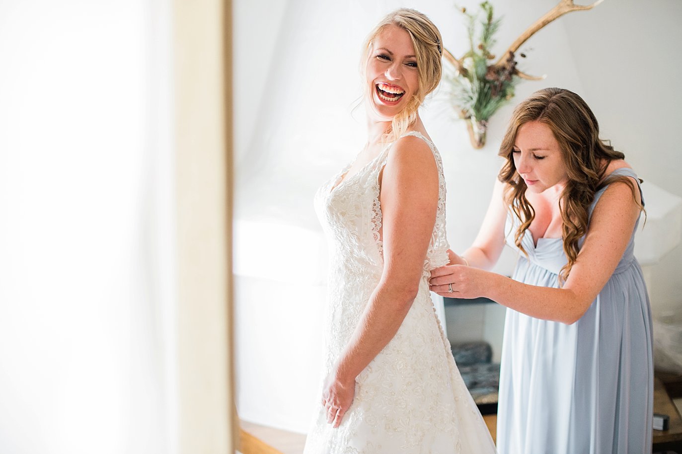 Bride getting dressed at Sonnenalp Hotel by Vail wedding photographer Jennie Crate