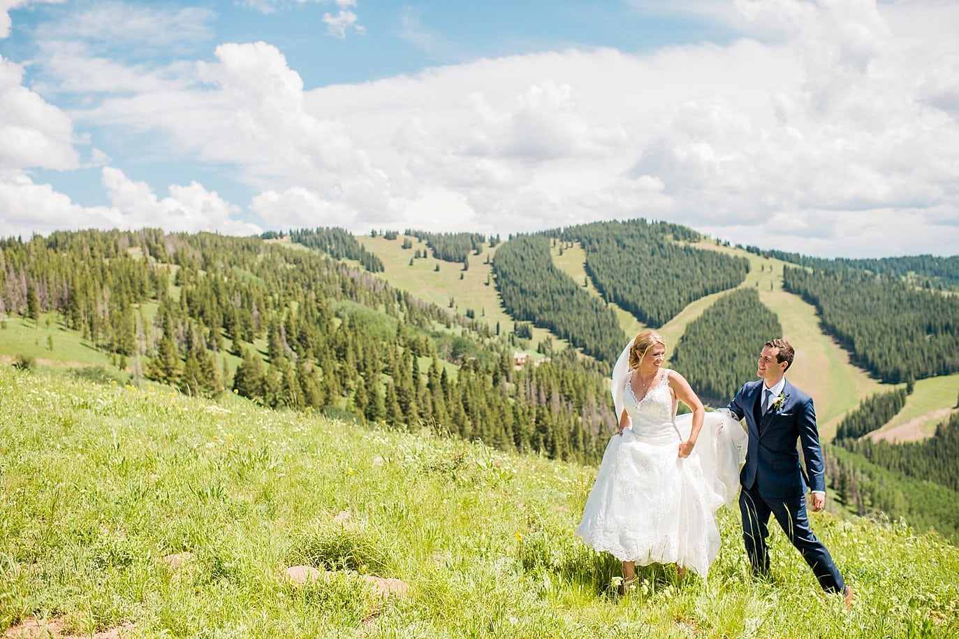 bride and groom walking at top of Vail Mountain by Vail wedding photographer Jennie Crate