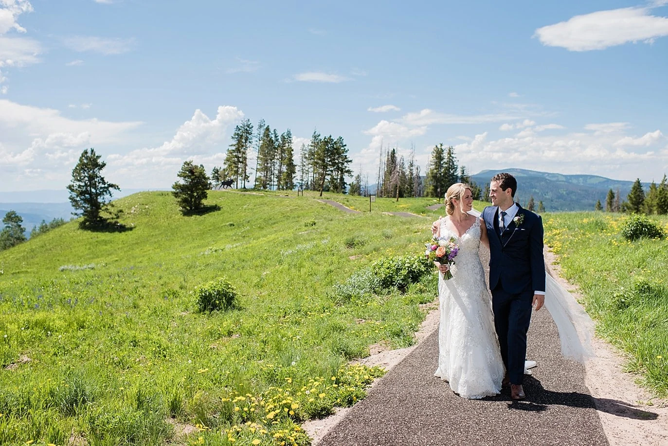 bride and groom walking at summer Vail Mountain wedding by Avon wedding photographer Jennie Crate