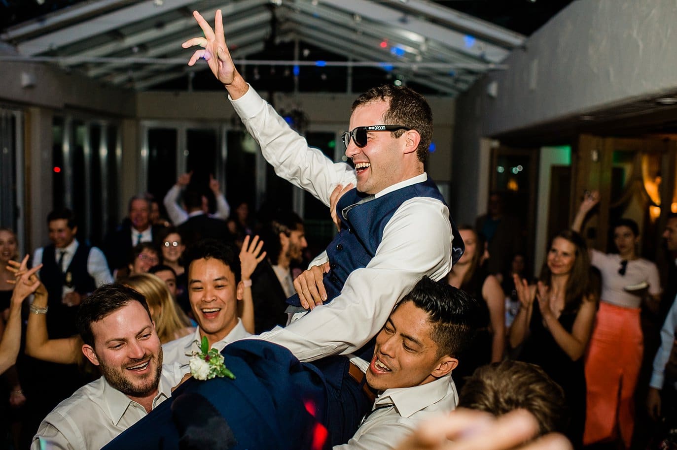 Groom being held up in dance at Summer Sonnenalp Hotel Vail wedding by Vail wedding photographer Jennie Crate