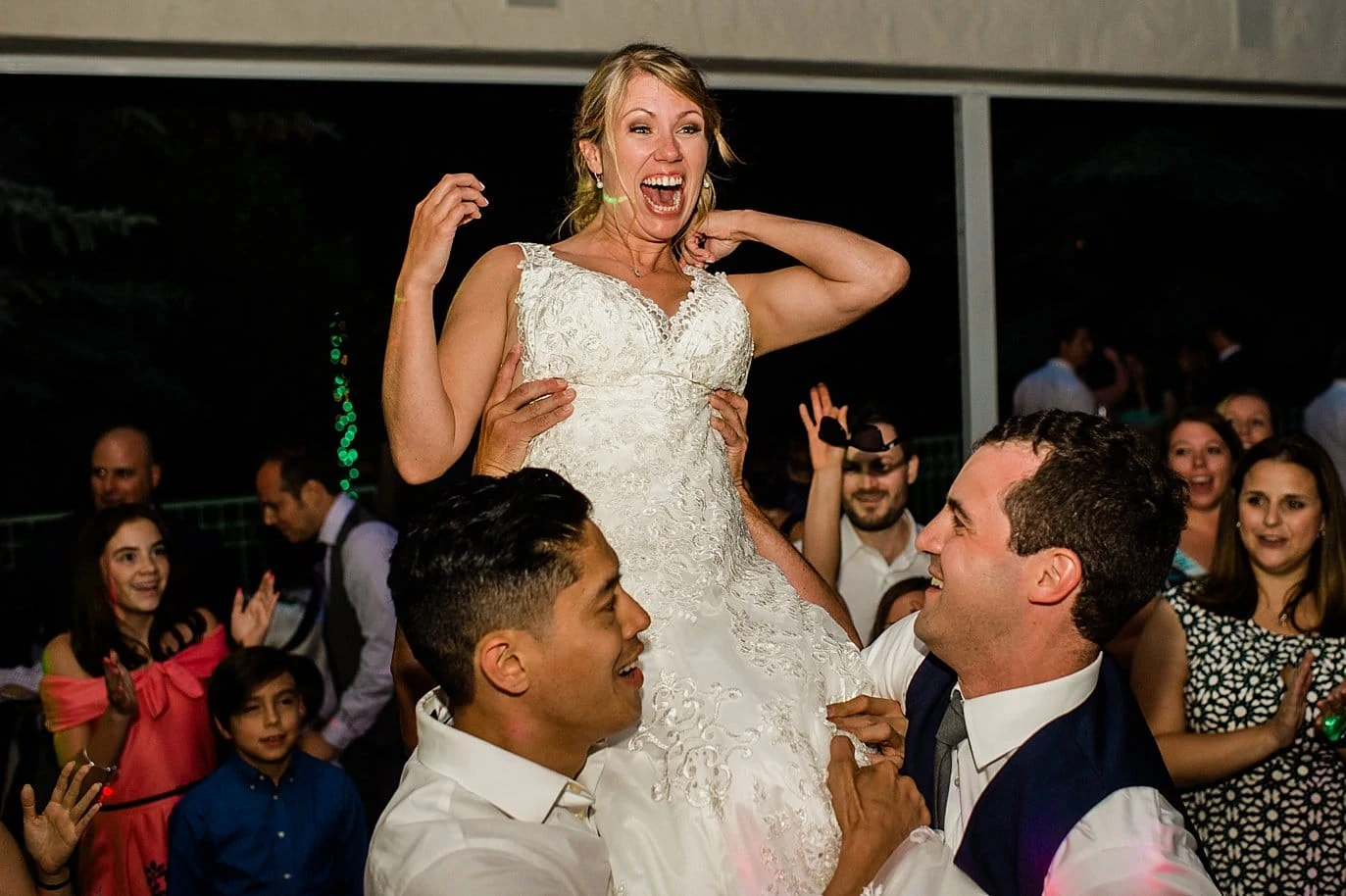 Bride being lifted at Summer Sonnenalp Hotel Vail wedding by mountain wedding photographer Jennie Crate