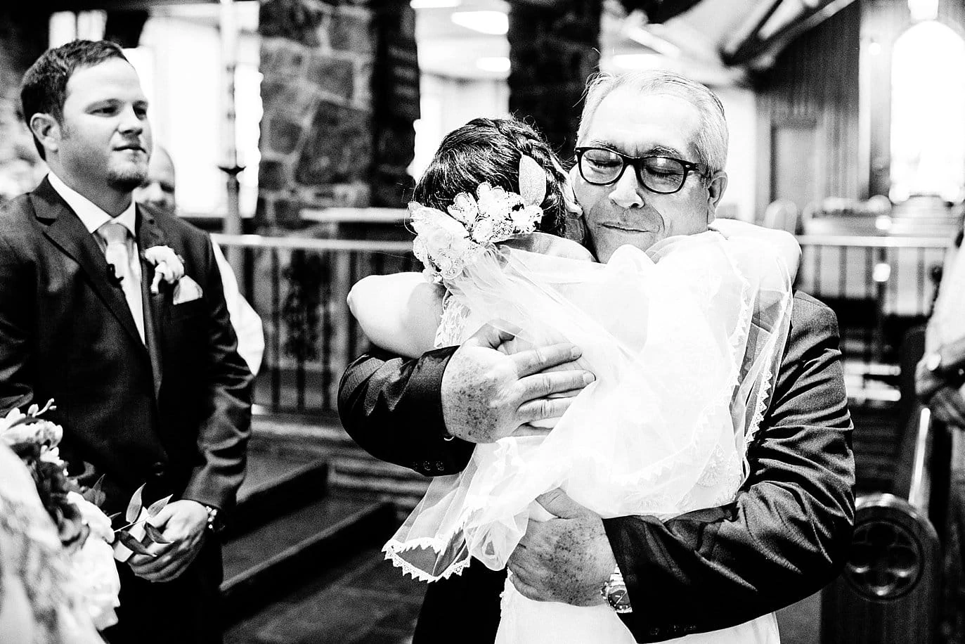 bride hugging dad at Our Lady of the Mountains Catholic Church wedding ceremony by Estes Park wedding photographer Jennie Crate