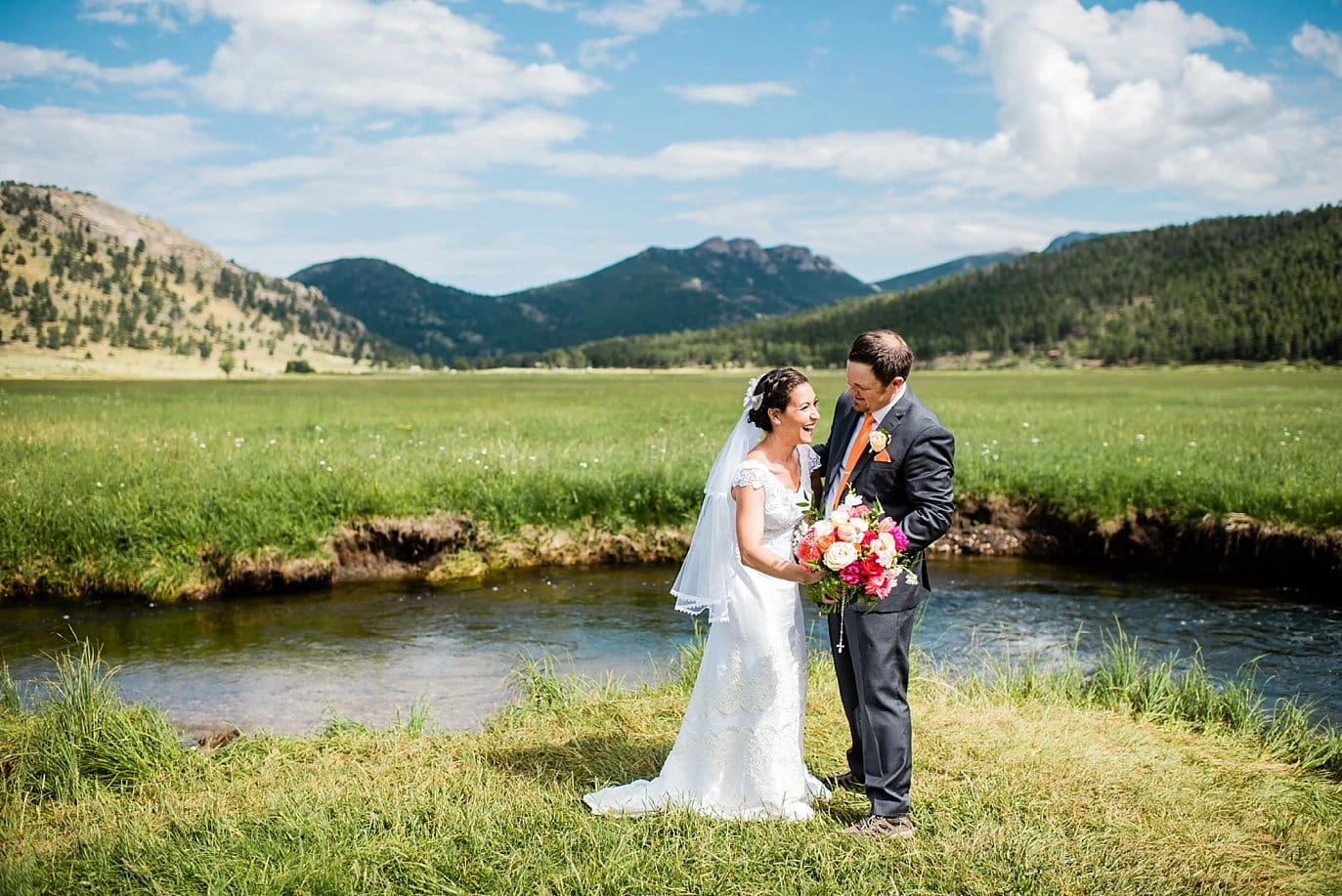 bride and groom by creek at Moraine Valley by Estes Park wedding photographer Jennie Crate