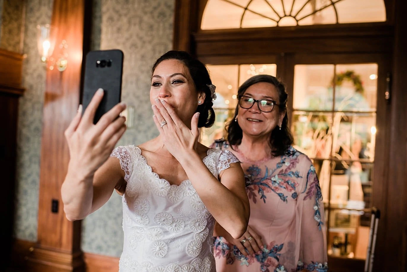bride blowing kisses to FaceTime relative on Wedding Day at The Stanley Hotel wedding by Estes Park wedding photographer Jennie Crate