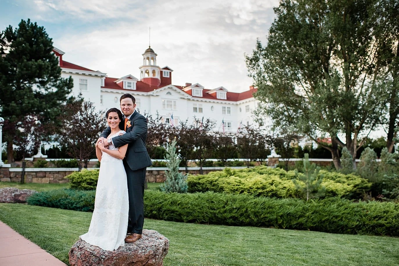 couple in front of iconic view at The Stanley Hotel wedding by Estes Park wedding photographer Jennie Crate