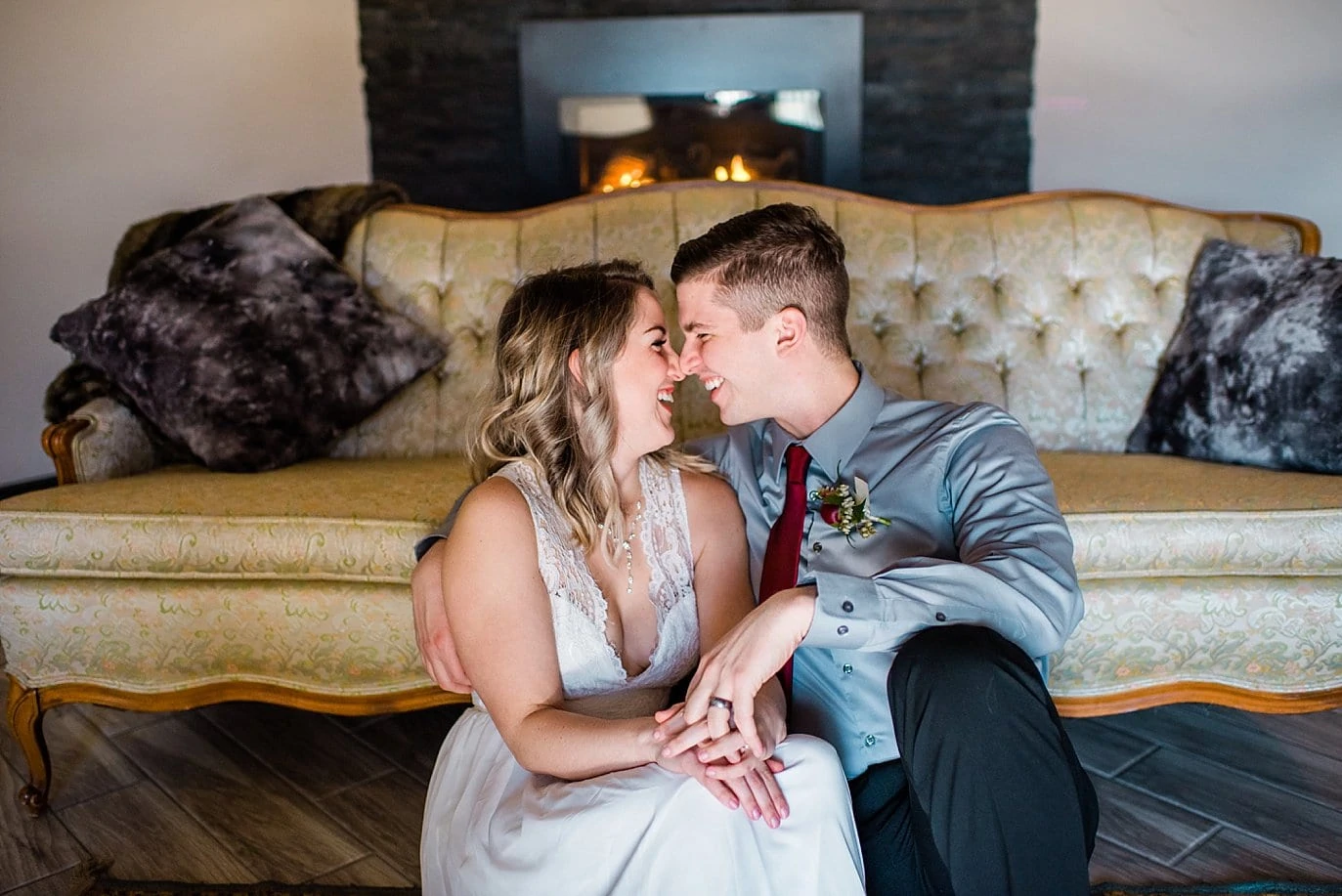 bride and groom snuggling by fireplace in winter at Northgate Event Center wedding by Thornton wedding photographer Jennie Crate