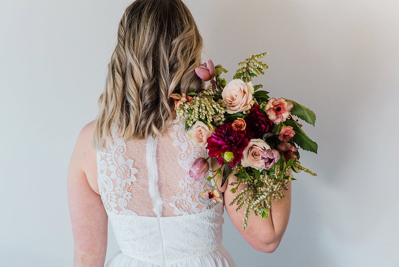 bride with lace dress and merlot and rose bridal bouquet at Northgate Event Center wedding by Westminster wedding photographer Jennie Crate