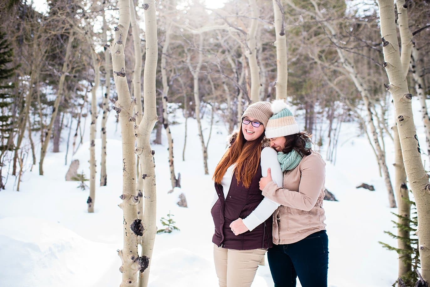 two brides in snow during Alberta Falls Rocky Mountain National Park winter hiking engagement by Fort Collins engagement photographer Jennie Crate, Photographer