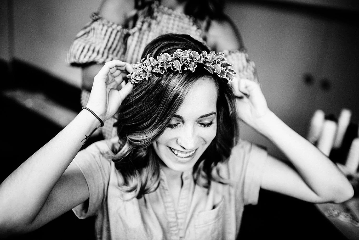 bride puts on floral crown at Arapahoe Basin wedding by Breckenridge wedding photographer Jennie Crate