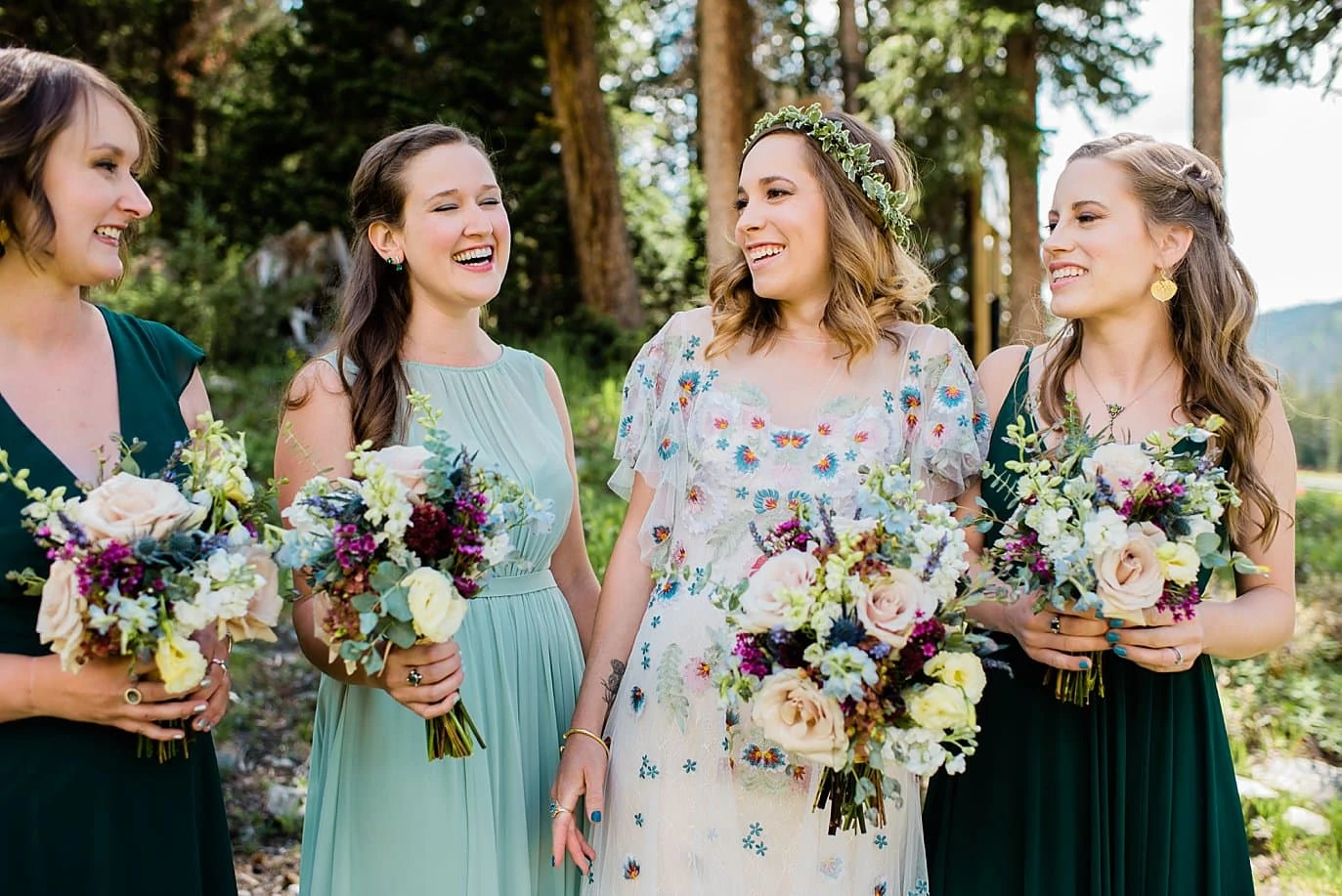 bride in unique boho floral dress and bridesmaids in green dresses at Arapahoe Basin wedding by Rocky Mountain Wedding photographer Jennie Crate photographer