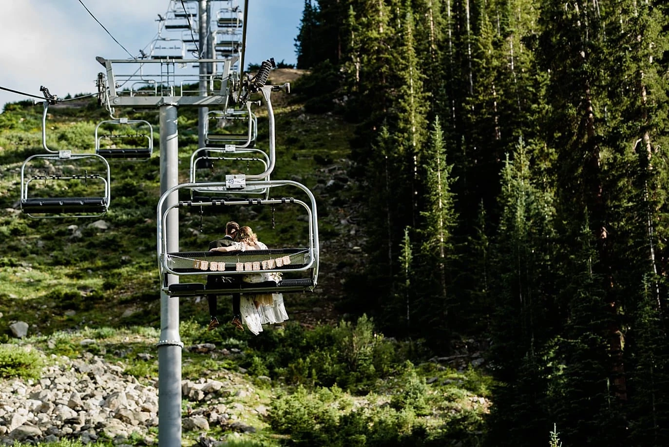 bride and groom ride chair lift after wedding ceremony at Black Mountain Lodge by at Arapahoe Basin wedding by Vail wedding photographer