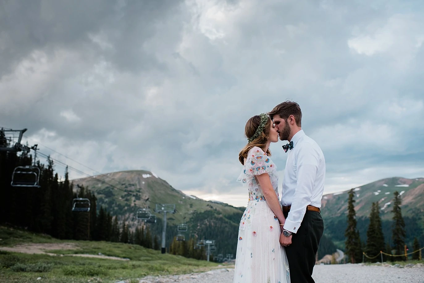bride and groom sunset portrait at top of black mountain lodge at Arapahoe Basin wedding by Vail wedding photographer