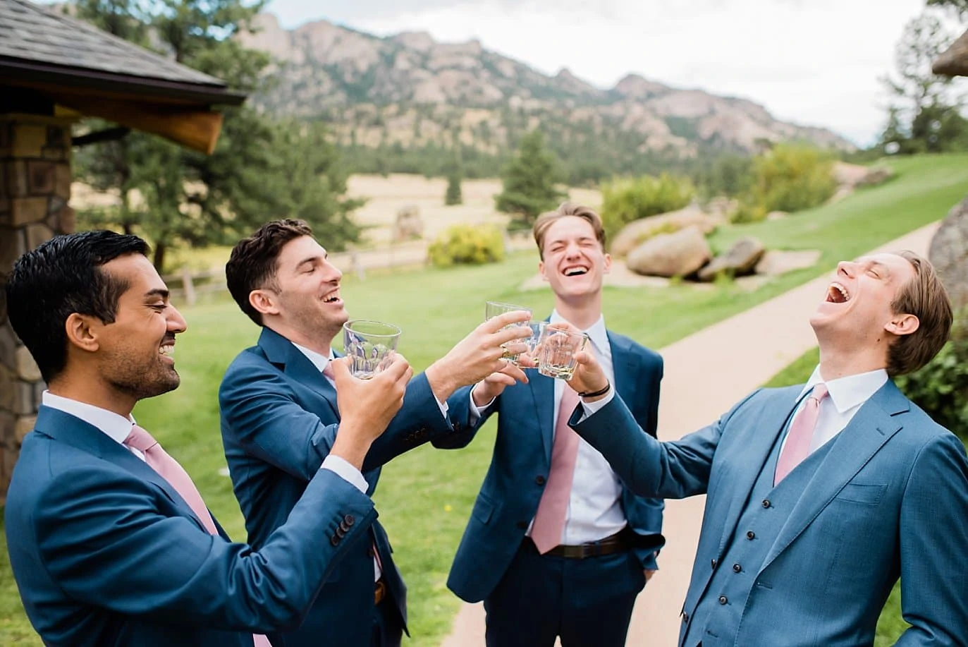 groom and groomsmen toasting with whiskey shots at Black Canyon Inn wedding by Boulder wedding photographer Jennie Crate Photographer