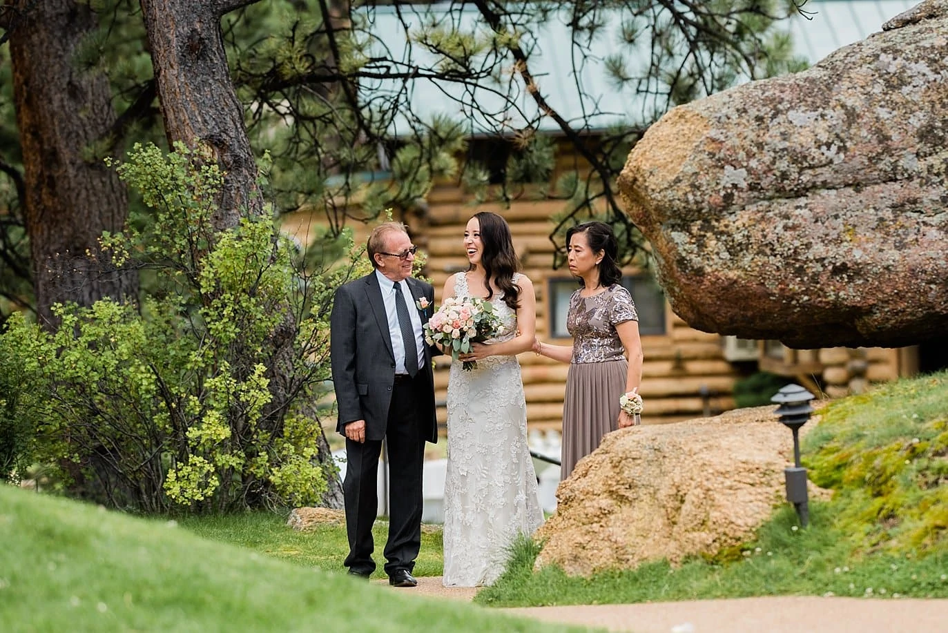 bride gets ready to walk down aisle with parents between boulders at Black Canyon Inn wedding by Boulder wedding photographer Jennie Crate Photographer