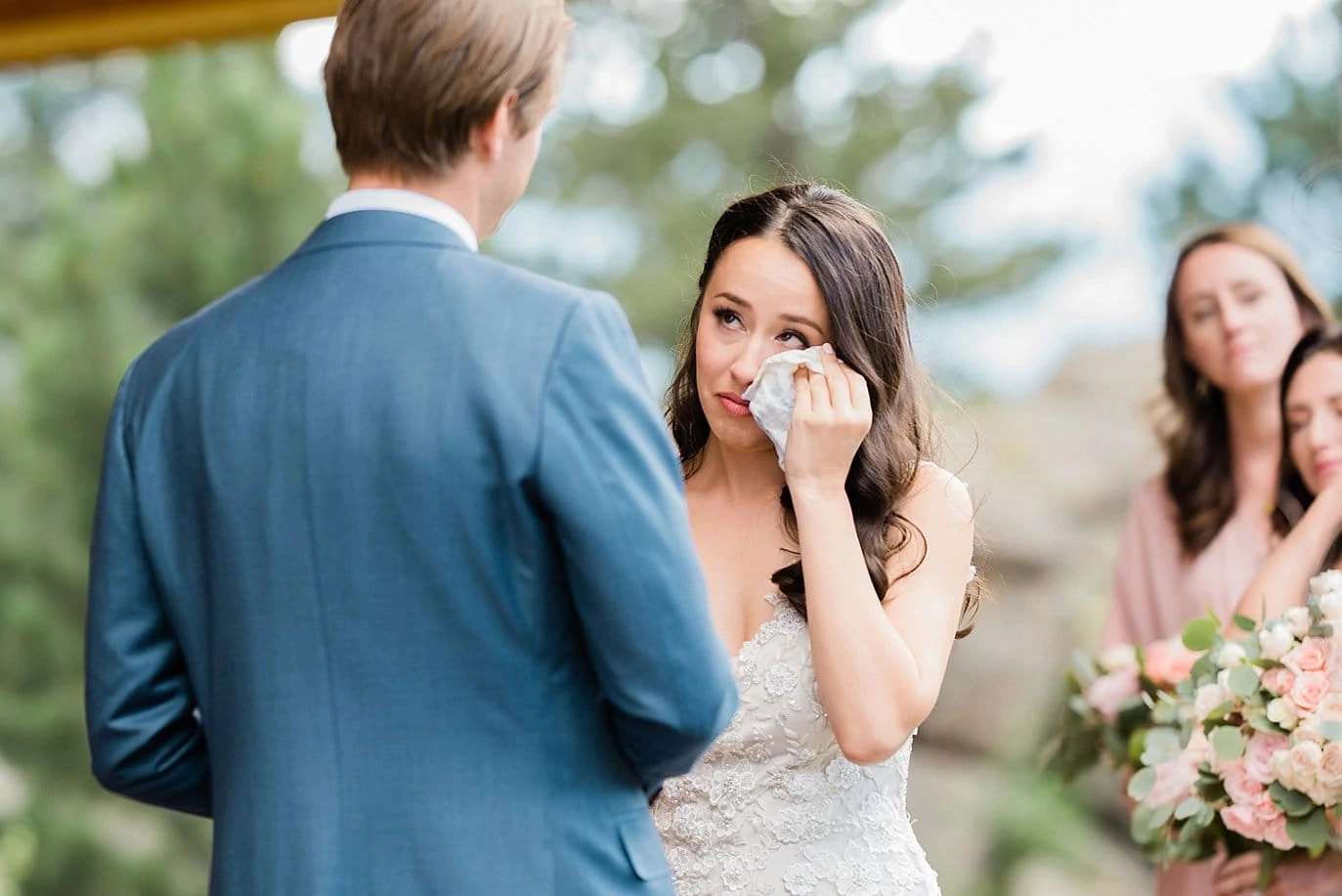 bride wipes away tears during vows Black Canyon Inn wedding by Estes Park wedding photographer Jennie Crate Photographer