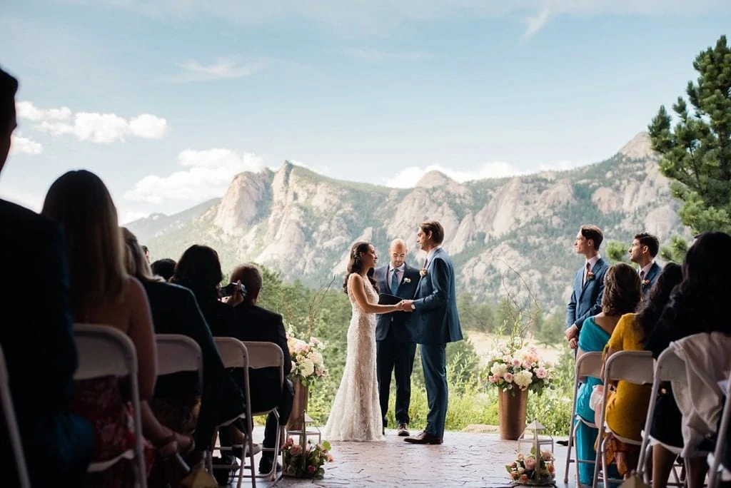bride and groom in front of mountains during wedding ceremony at Black Canyon Inn wedding by Denver wedding photographer Jennie Crate Photographer