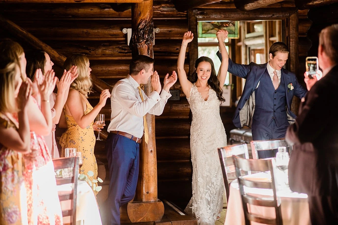 bride and groom make grand entrance into their reception at t Twin Owls Steakhouse wedding by Estes Park wedding photographer Jennie Crate photographer