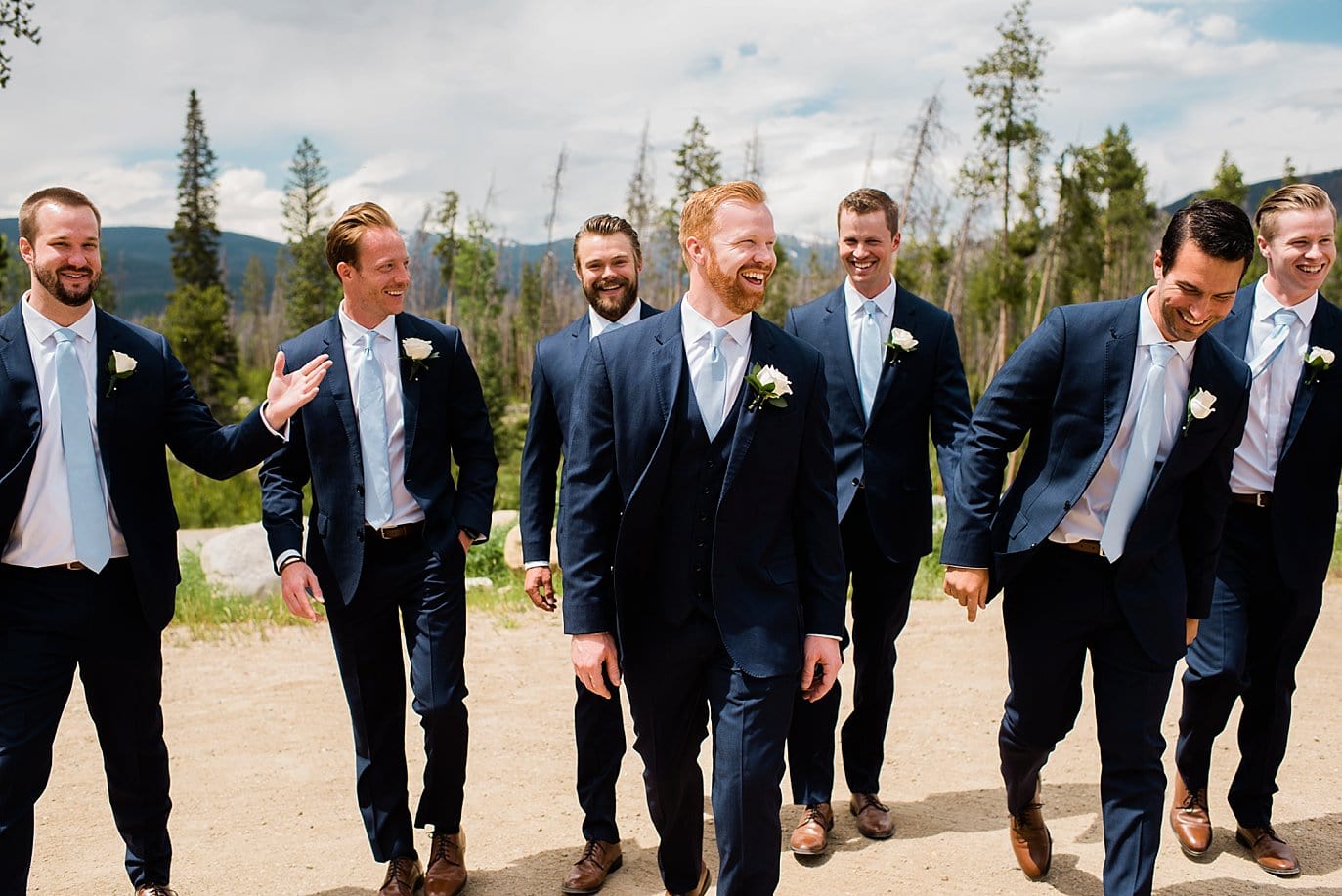 groom and groomsmen walking in sunshine of Rocky Mountains at Grand Lake Lodge wedding by Grand Lake wedding photographer Jennie Crate