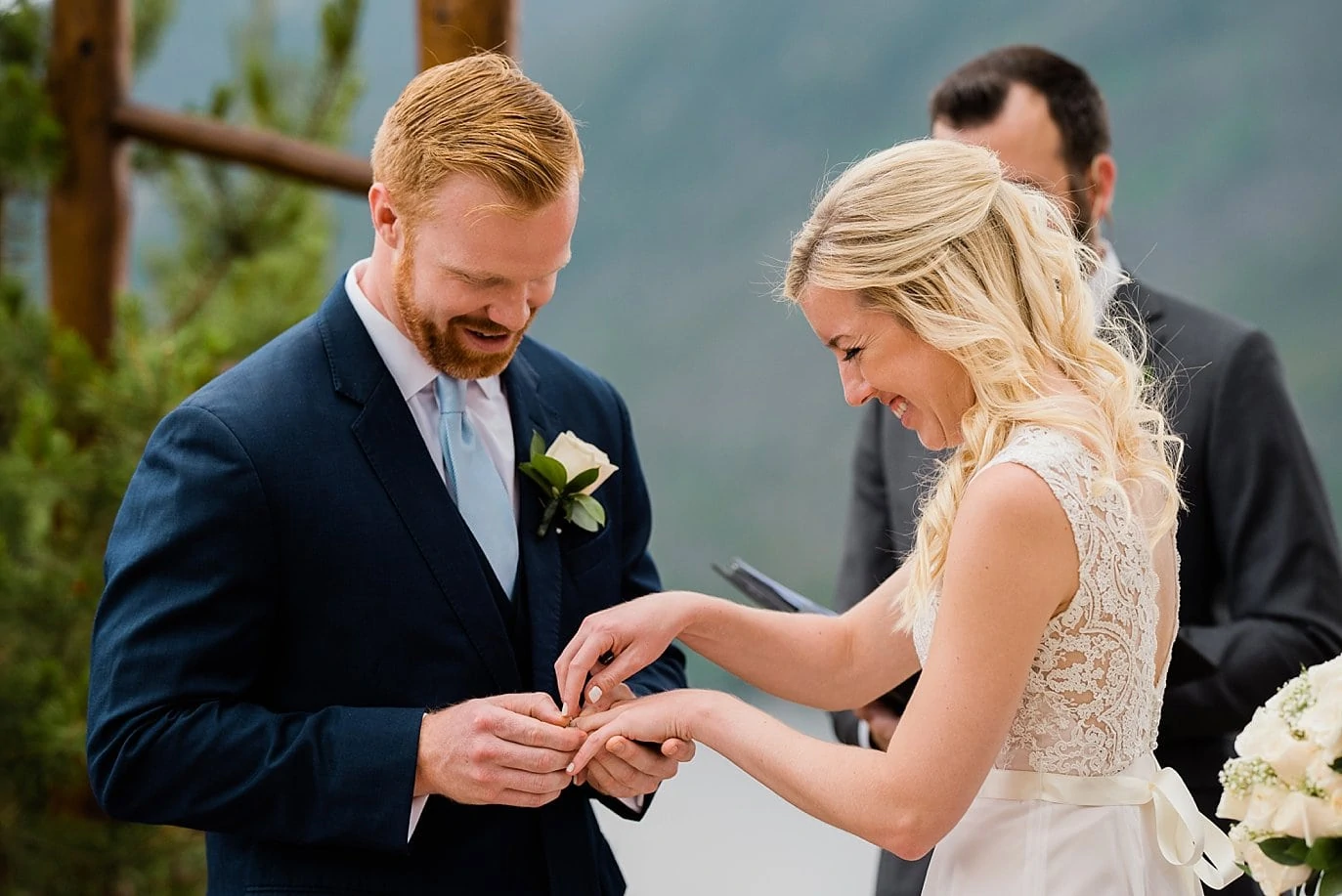 bride and groom exchange rings at wedding ceremony at pavilion at Grand Lake Lodge wedding by Boulder wedding photographer Jennie Crate