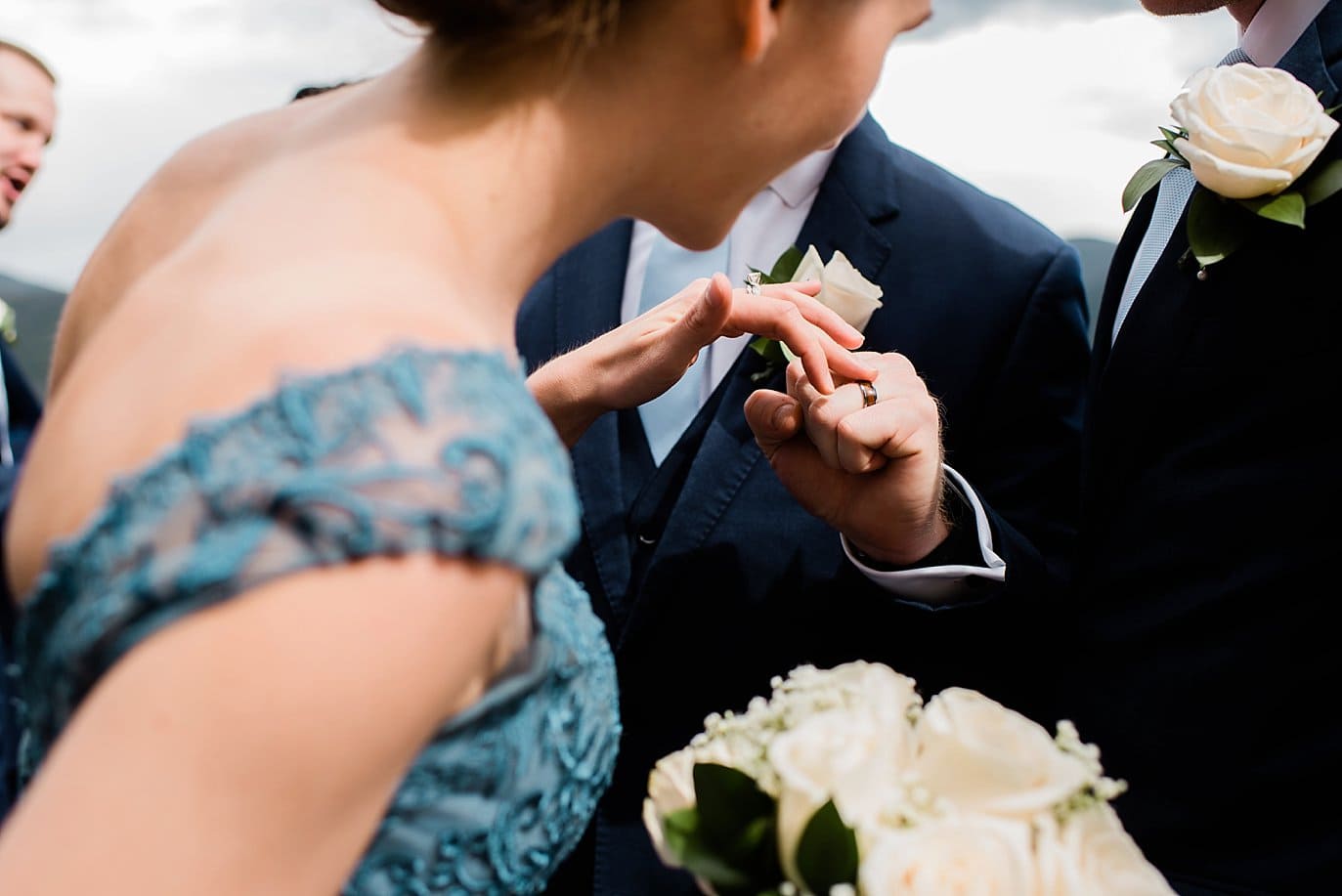 bridesmaid inspects grooms wedding ring at Grand Lake Lodge wedding by Granby wedding photographer Jennie Crate