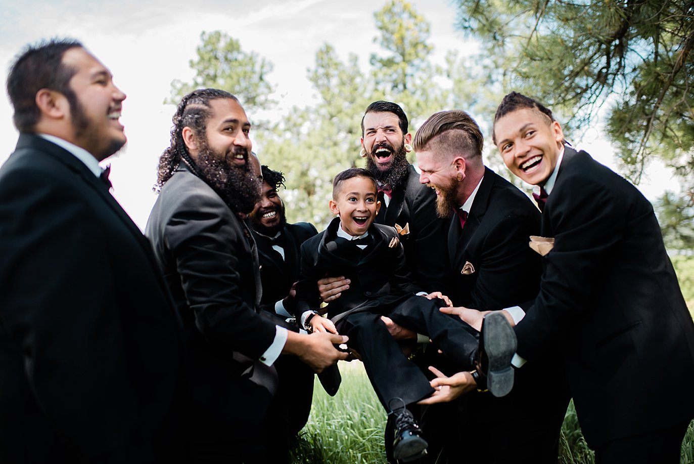 groomsmen tossing ring bearer into the air at Pagosa Springs wedding by Denver Wedding Photographer Jennie Crate