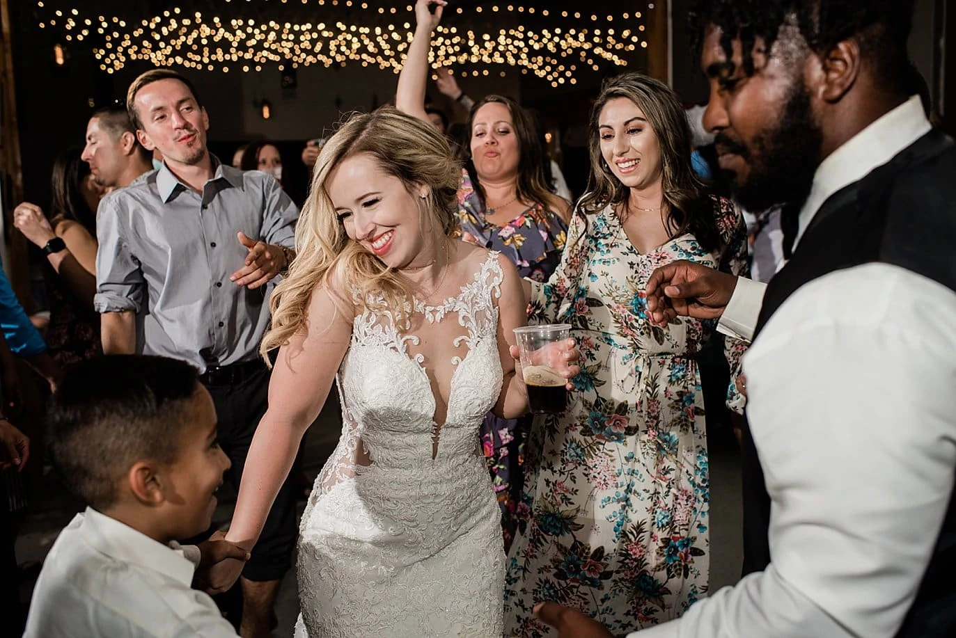 bride dances with guests during wedding reception in barn at at Pagosa Springs wedding by Pagosa Springs Wedding Photographer Jennie Crate