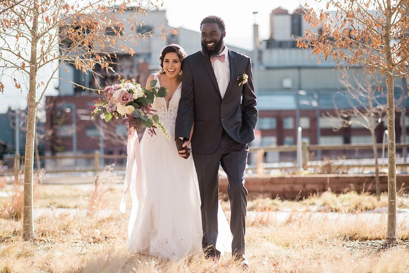 bride and groom walking among trees of industrial space at Shyft Denver wedding by Denver wedding photographer Jennie Crate photographer