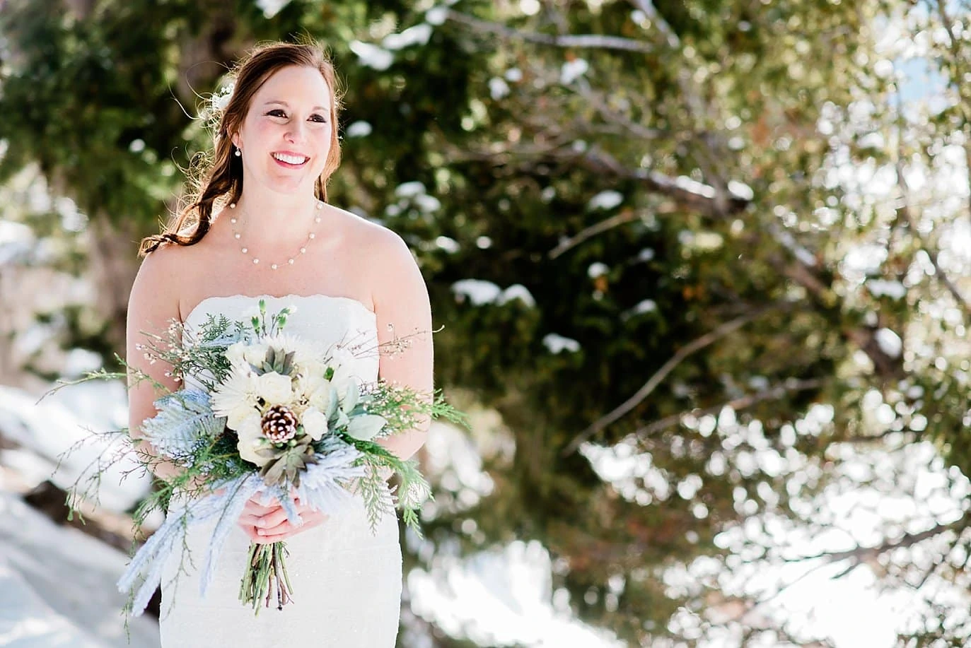 bride in strapless dress with neutral winter flowers at Sapphire Point Elopement by Dillon wedding photographer Jennie Crate Photographer