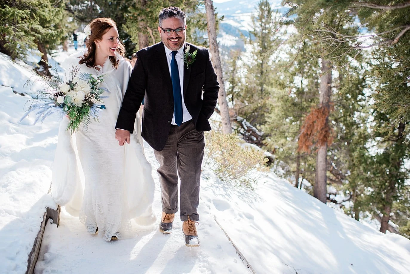 bride and groom walk in snow at Sapphire Point Elopement by Dillon wedding photographer Jennie Crate Photographer