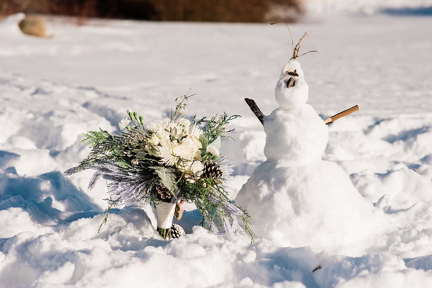 snowman and bridal bouquet on winter wedding day at Sapphire Point Elopement by Dillon wedding photographer Jennie Crate Photographer