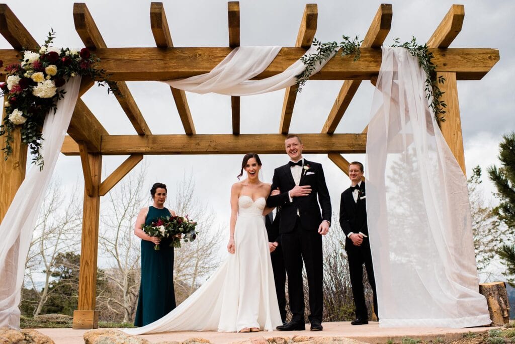 Bride and groom ceremony at Taharaa Mountain Lodge wedding by Estes park wedding photographer Jennie Crate
