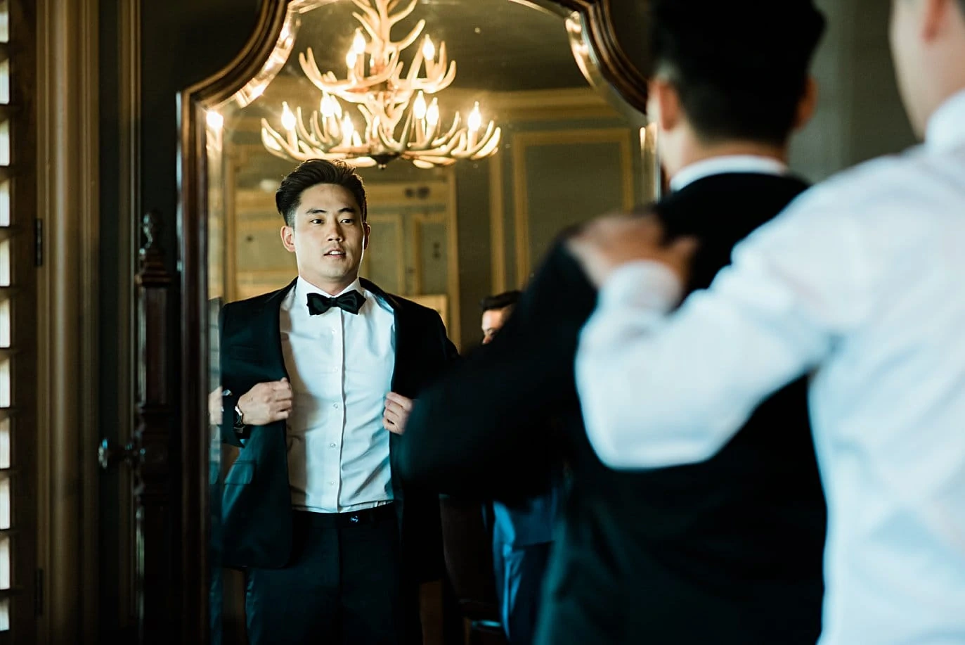 groom putting on tuxedo at Highlands Ranch Mansion wedding by Denver wedding photographer Jennie Crate