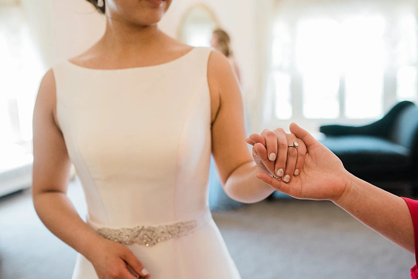 bride holds mom's hand before walking down aisle at Highlands Ranch Mansion wedding by Denver wedding photographer Jennie Crate