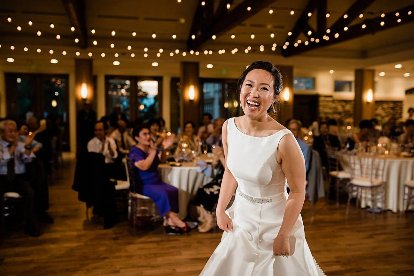 bride laughing on dance floor at Highlands Ranch Mansion wedding by Boulder wedding photographer Jennie Crate