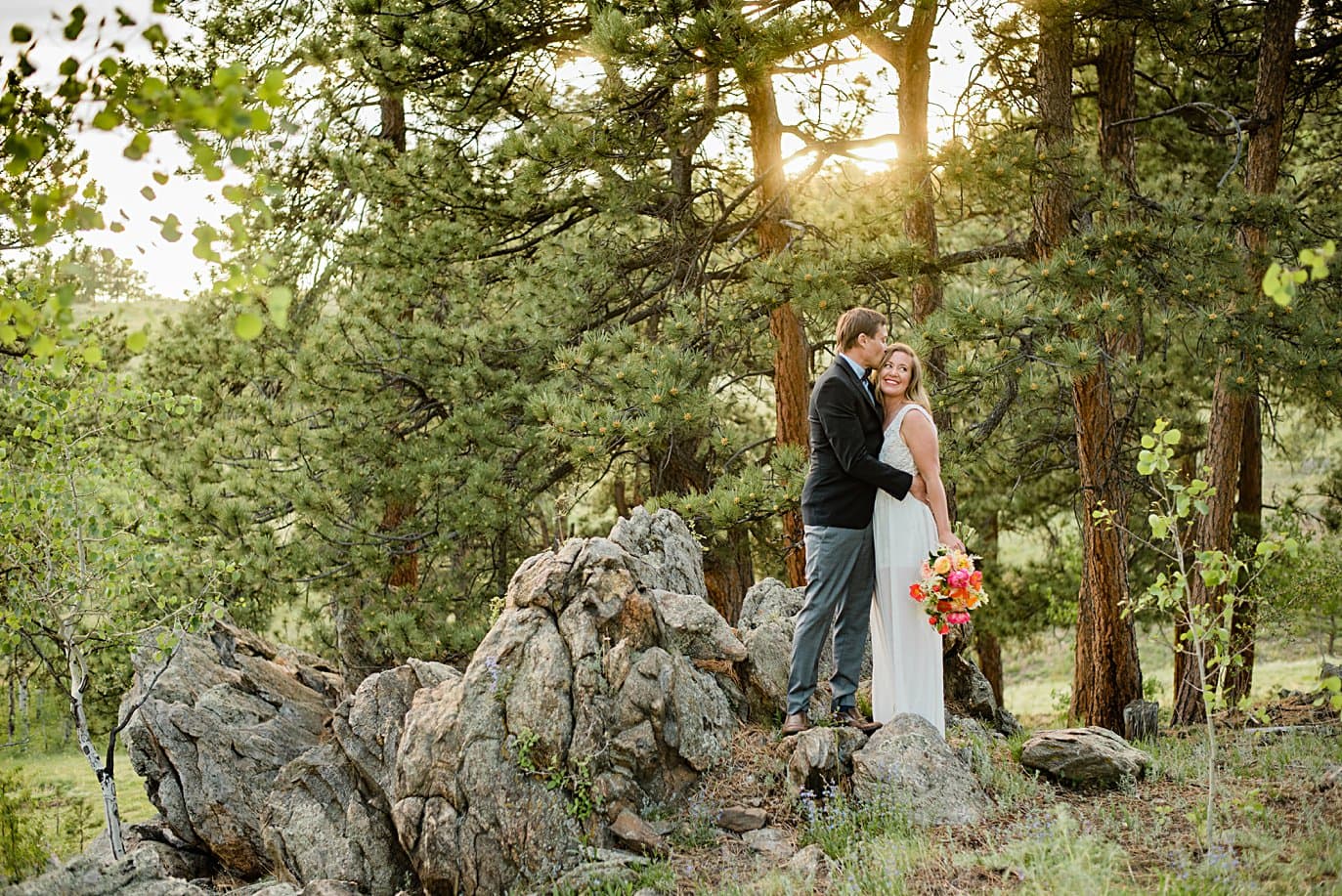 bride and groom cuddle by rock formations at Golden elopement by Golden elopement photographer Jennie Crate