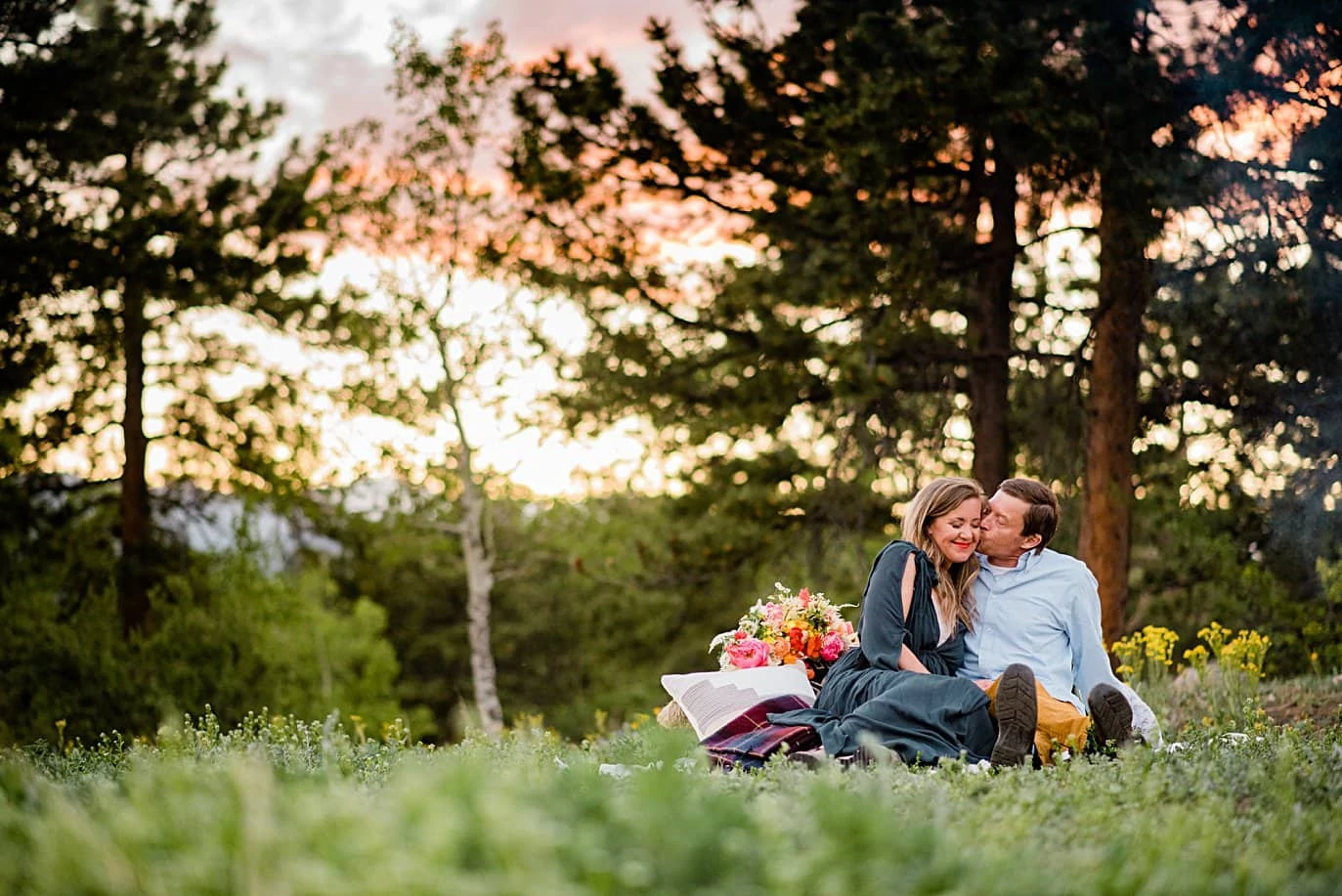 couple cuddles in grass at sunset at Golden elopement by Golden elopement photographer Jennie Crate